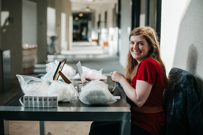 A smiling volunteer sitting behind the registration desk