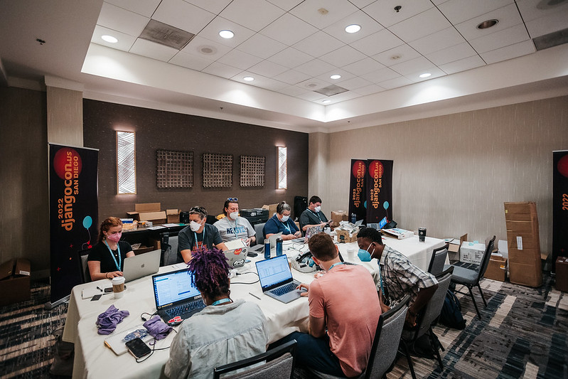 Organizers at DjangoCon US 2022 in San Diego preparing before the conference. But it looks like they could be co-writing!